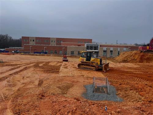 Bruns Avenue parking lot under construction; bulldozer moving dirt