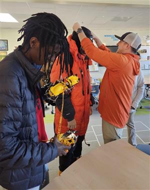 Students trying on climbing gear