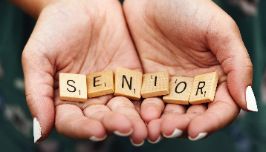  hands holding scrabble blocks that spell out senior