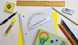  pens and pencils with graph paper with a protractor on the graph paper