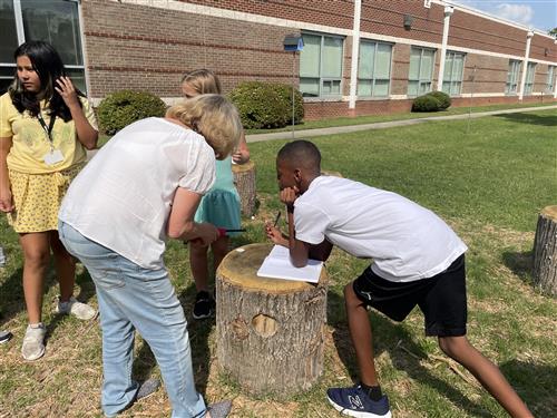 Teacher helping student in outdoor classroom