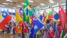People standing in front of international flags