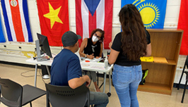 People talking around a table in front of international flags