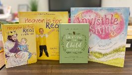  Four books lined across a table that talk about loss of a loved one
