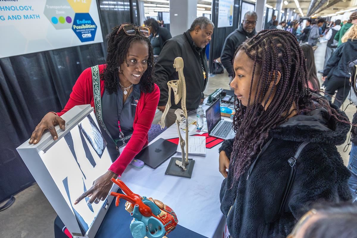 A teacher points out x-ray photos to a student
