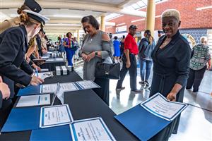 Volunteer honorees picking up certificates at a table