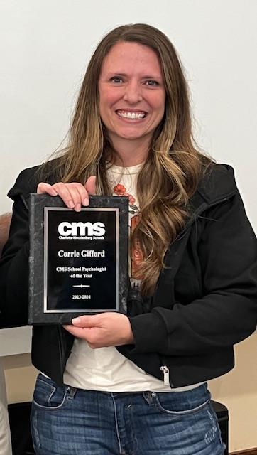 School Psychologist Corrie Gifford smiles with her School Psychologist of the Year plaque.