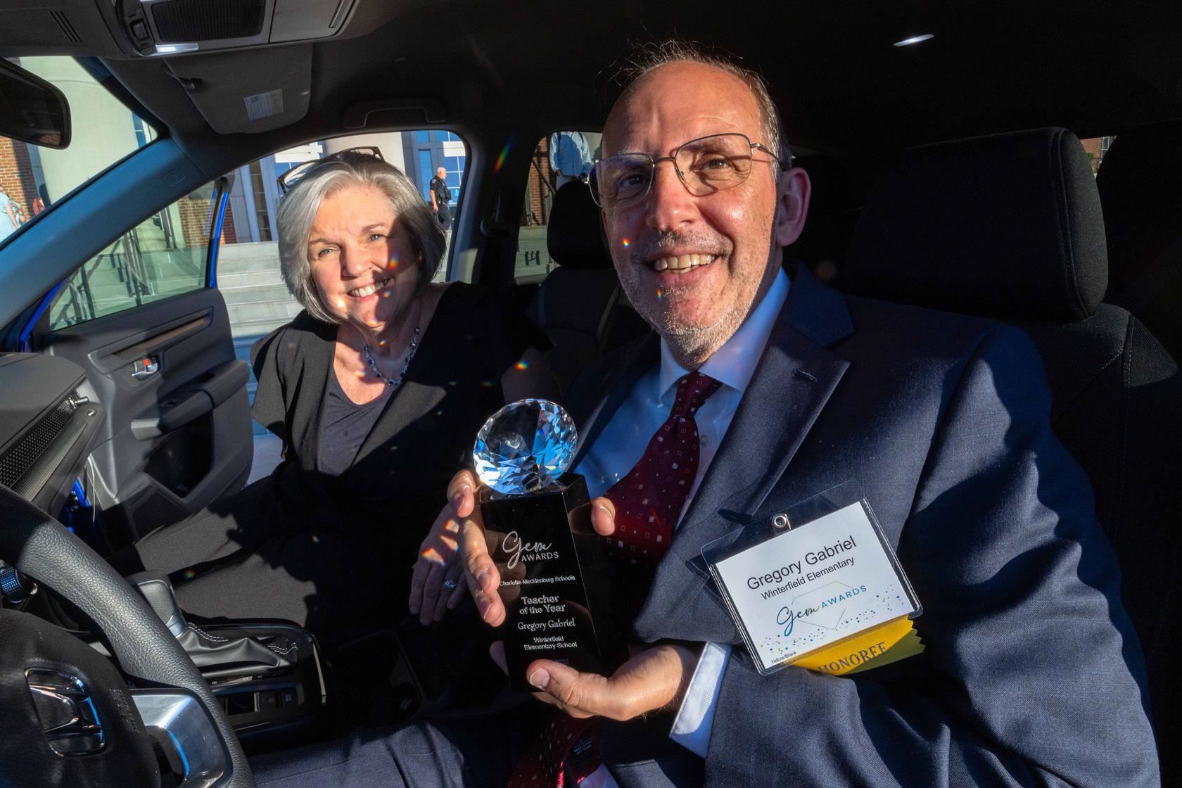 Gregory Gabriel smiles in his new car while holding his Gem Award