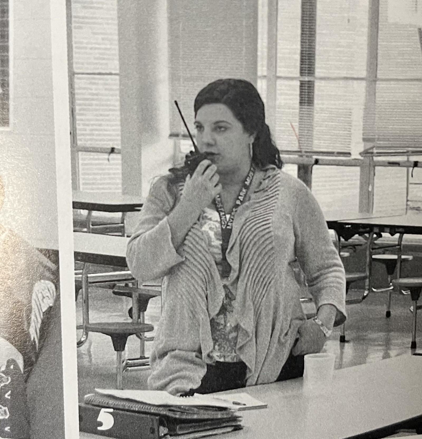 Brooklyn Hough stands with a walkie talkie at Myers Park High where she used to be the Dean of Students.
