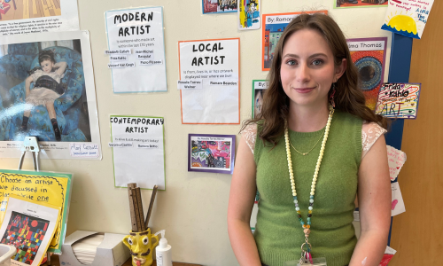  Katherine McDonald stands in front of a wall with posters behind her. 