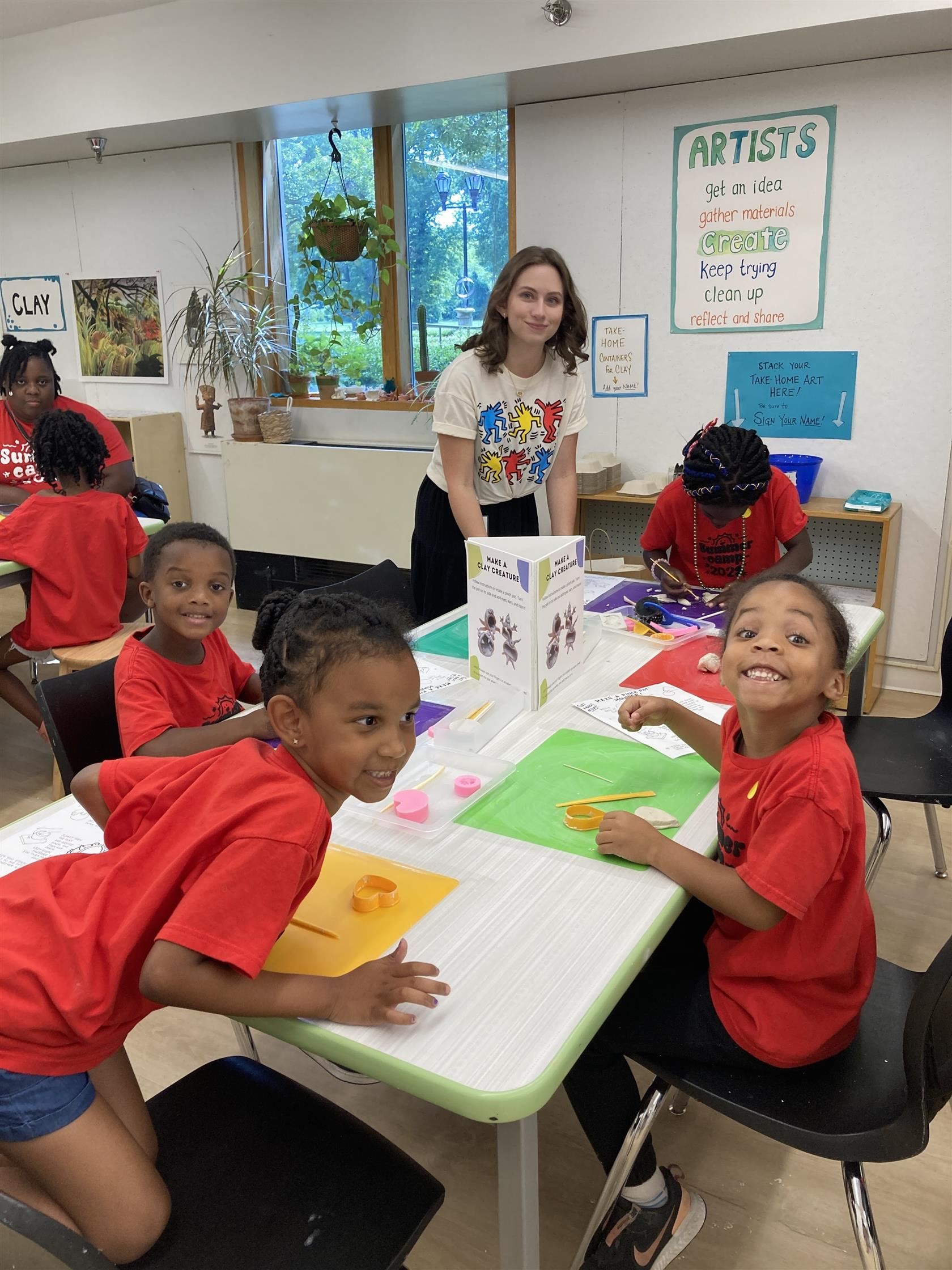 Katherine McDonald assisting students with their project at a table