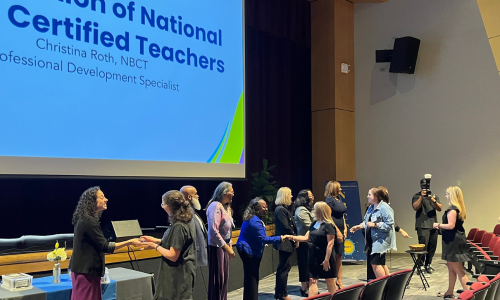 Educators stand in line to shake hands and receive their certification pins.