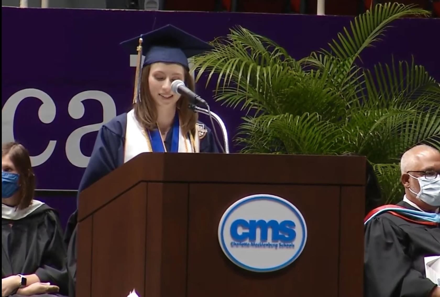 Katherine McDonald standing behind a CMS podium delivering her graduation speech
