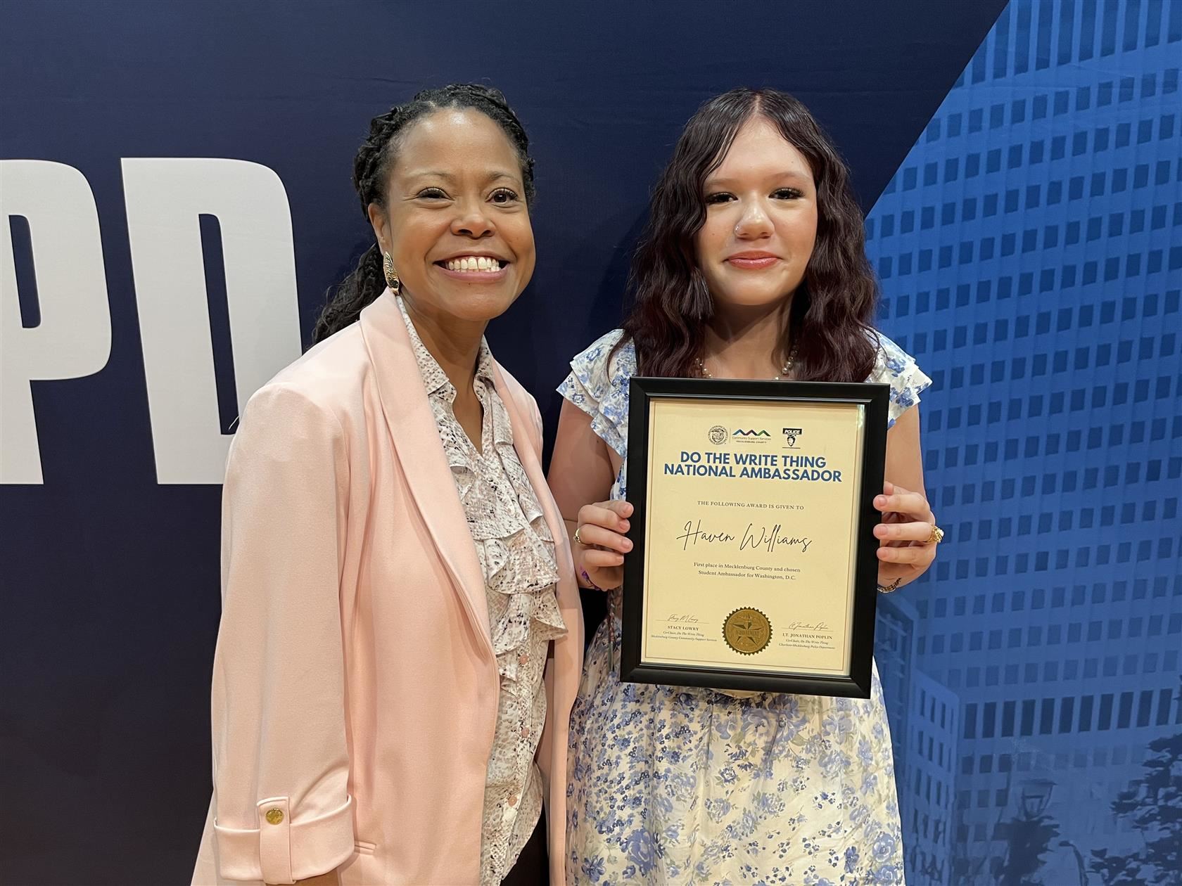 Haven Williams stands with her certificate next to CMS Superintendent Dr. Crystal Hill