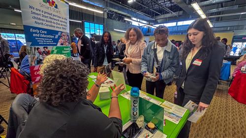 A group of female students speak with Smart Start representatives.