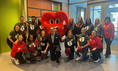  A group photo with a red heart mascot in the center. 