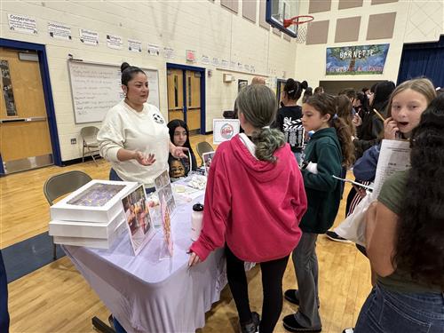 A baker talks to students at the Barnette Elementary Career Fair.