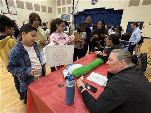 A dentist talks to students at the Barnette Elementary Career Fair.