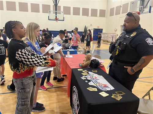 A police officer talks to students at the Barnette Elementary Career Fair.