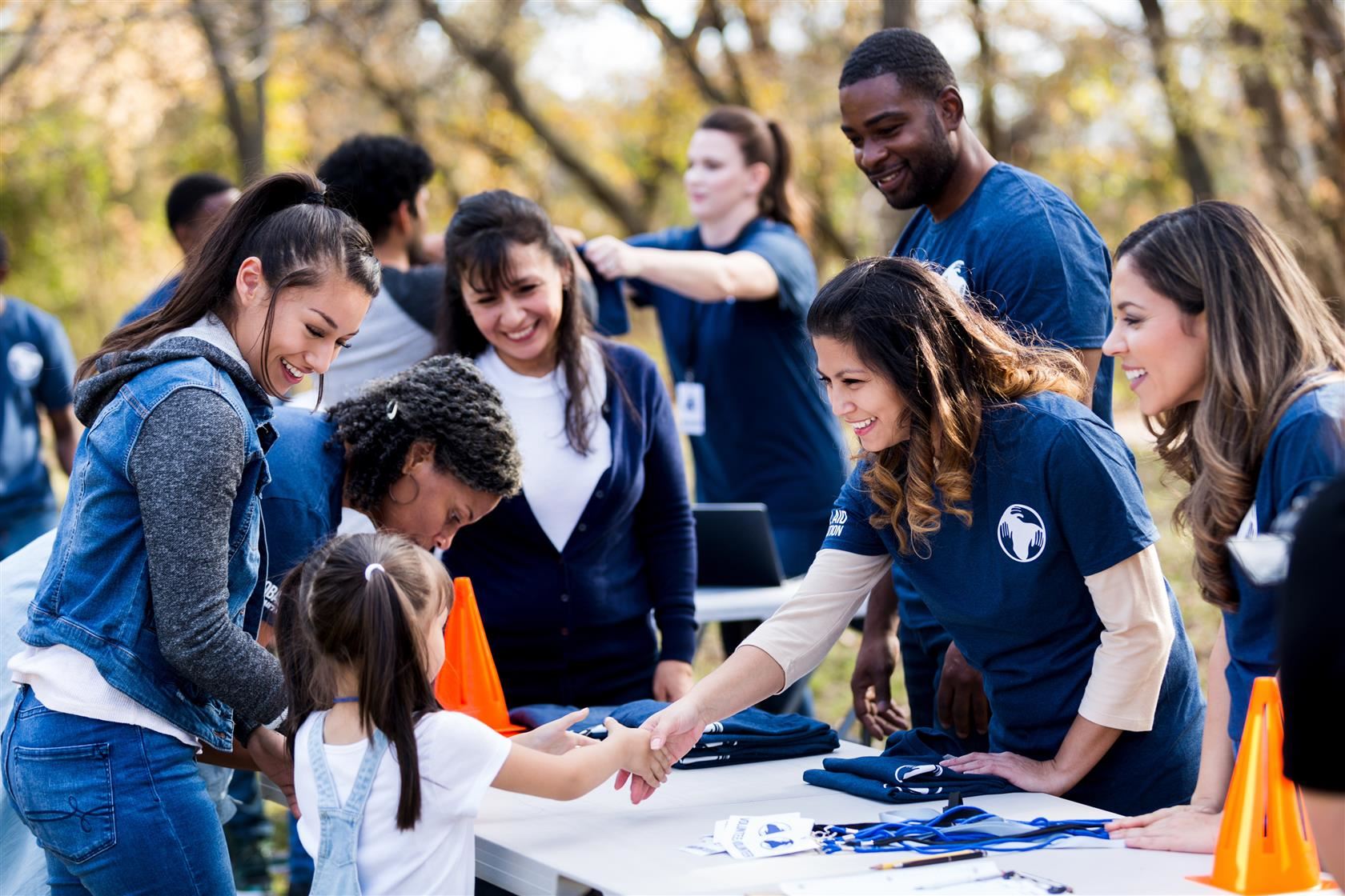 Group of volunteers and families at a registration table.