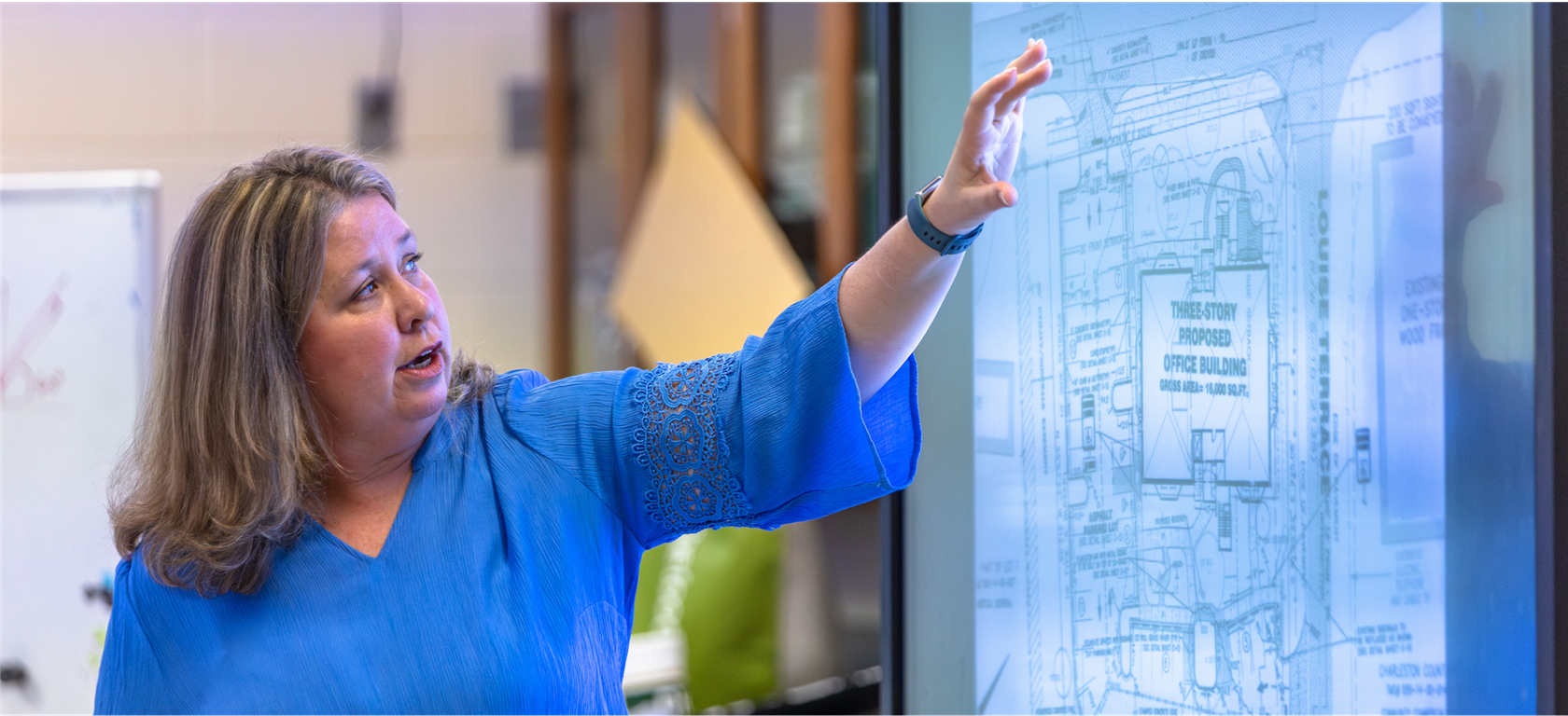 Person pointing to screen discussing data